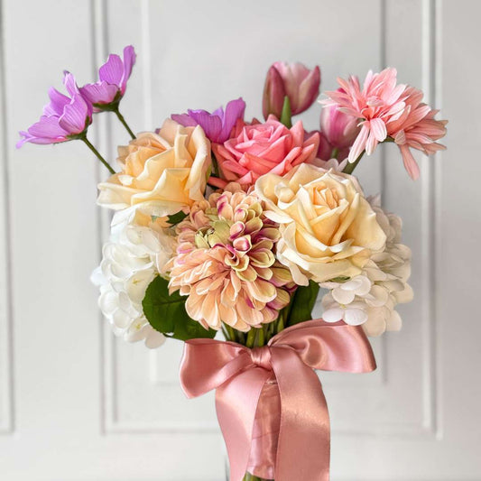 Rrealistic artificial flower bouquet featuring pink artificial tulips, champagne artificial tea roses, blush artificial peonies, white artificial hydrangeas, pink artificial dahlias, and lavender artificial cosmos tied with a satin ribbon — from My Faux Florist Canada.