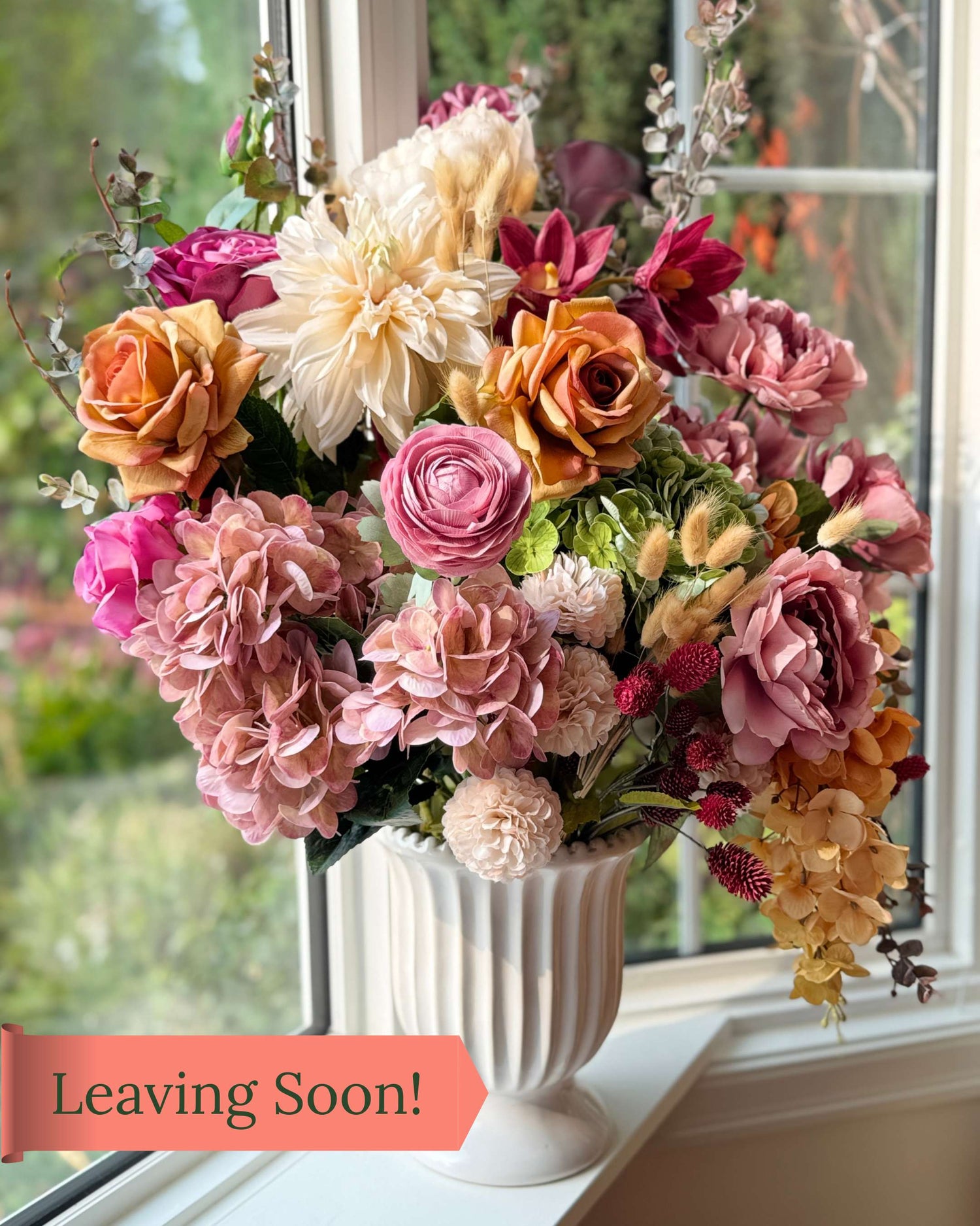 Elegant artificial flower arrangement in a white vase featuring cream artificial dahlias, apricot artificial roses, mauve artificial roses, pink artificial hydrangeas, blush artificial peonies, green artificial hydrangeas, burgundy artificial ranunculus, and golden artificial orchids — from My Faux Florist Canada.