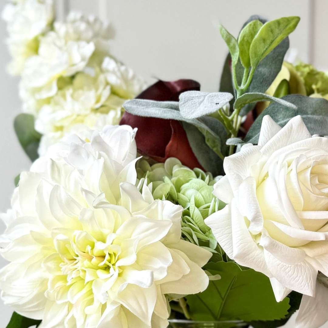 an artificial flower bridal bouquet featuring pale green artificial hydrangeas, white artificial dahlias, white artificial peonies, white artificial tea roses, white artificial Austin roses, and deep wine artificial calla lilies accented with soft lamb’s ear greenery — from My Faux Florist Canada.