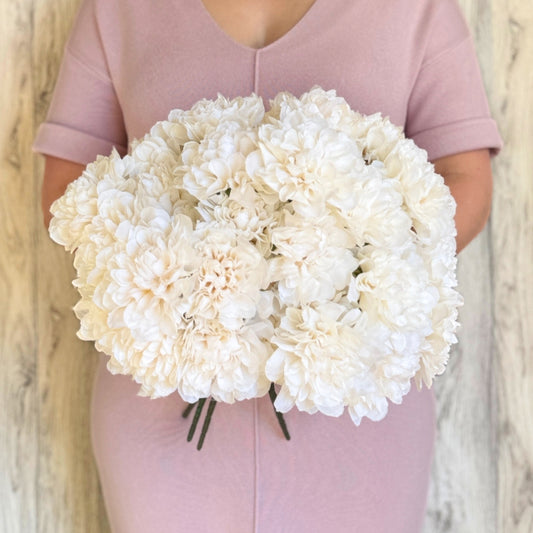 A person holding a bouquet of ivory artificial dahlia bushes with full, round-shaped petals by My Faux Florist Canada