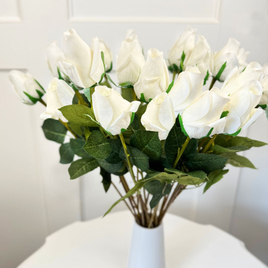 White artificial rosebuds displayed in a glass vase for floral styling inspiration, by Faux Florist Canada
