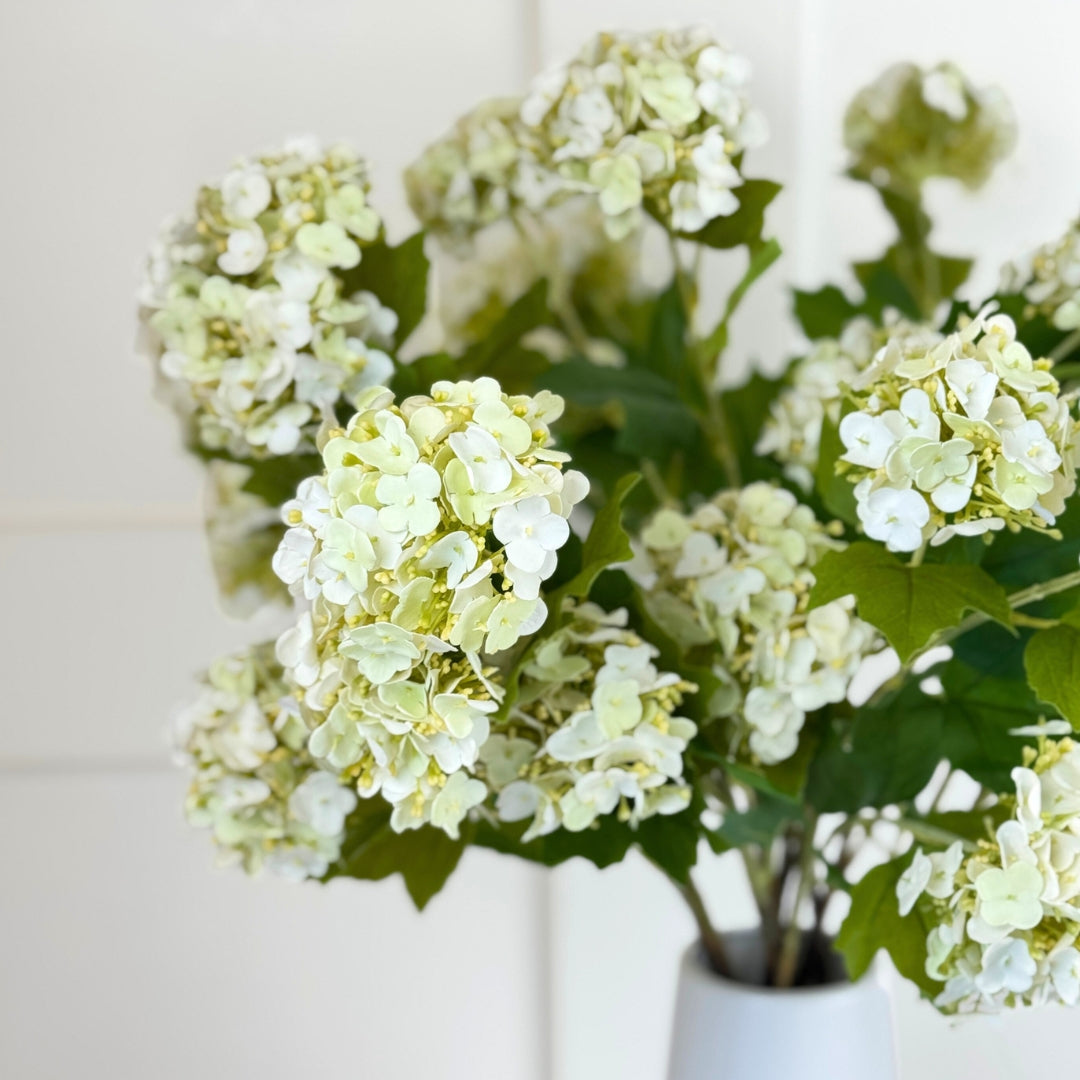 Vase full of white realistic artificial hydrangea stems with realistic Real Touch petals, from My Faux Florist artificial flowers Canada.