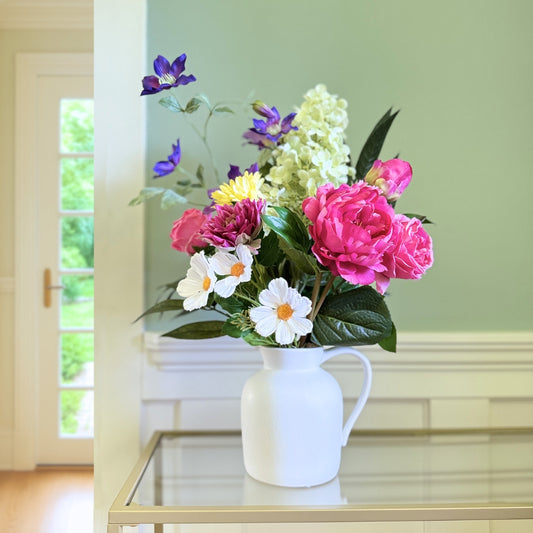 Bouquet of brightly coloured artificial flowers and Real Touch flowers in front of a green wall, by My Faux Florist artificial flowers Canada.