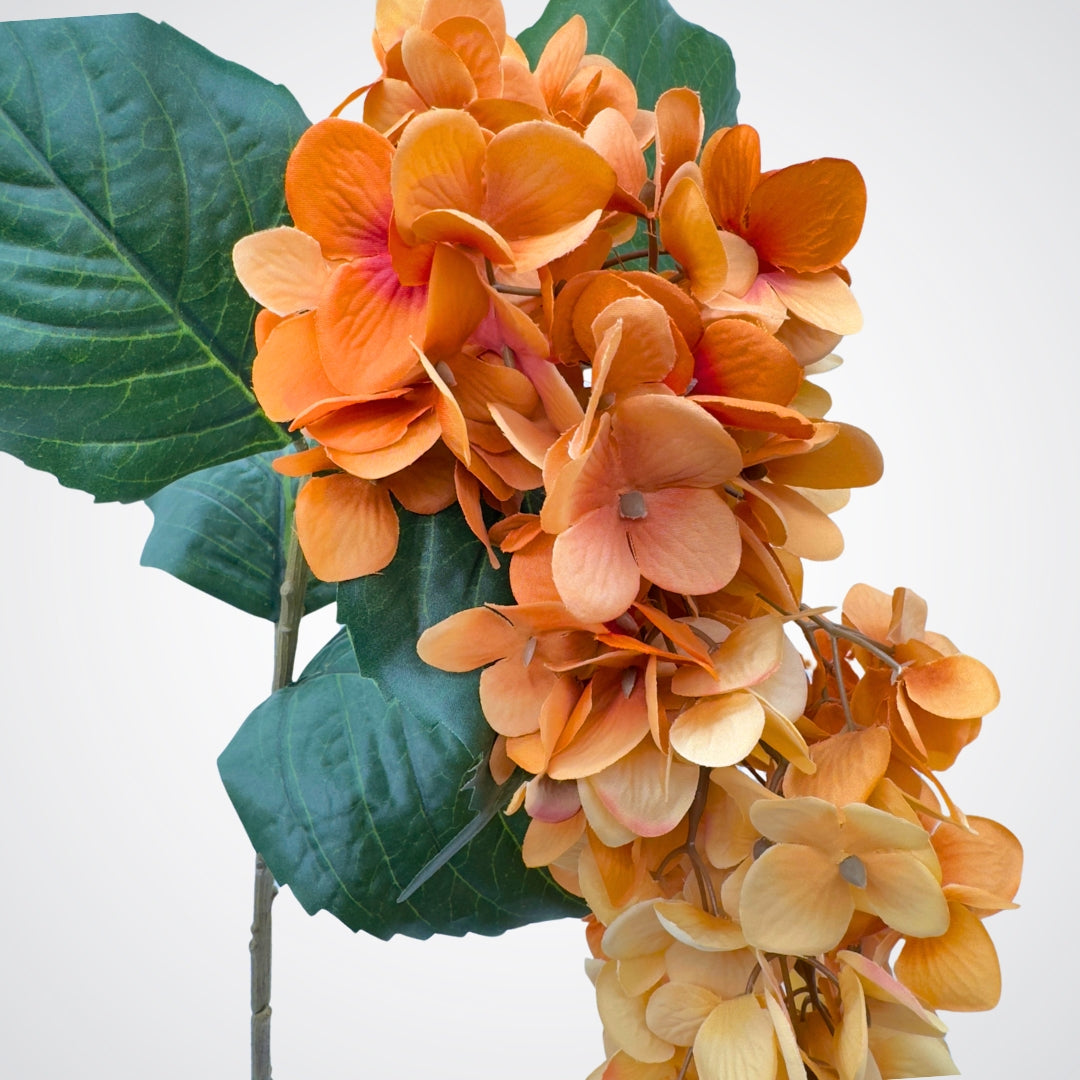 Close up of an artificial wisteria branch in ombre orange and bronze colours, by My Faux Florist artificial flowers Canada.