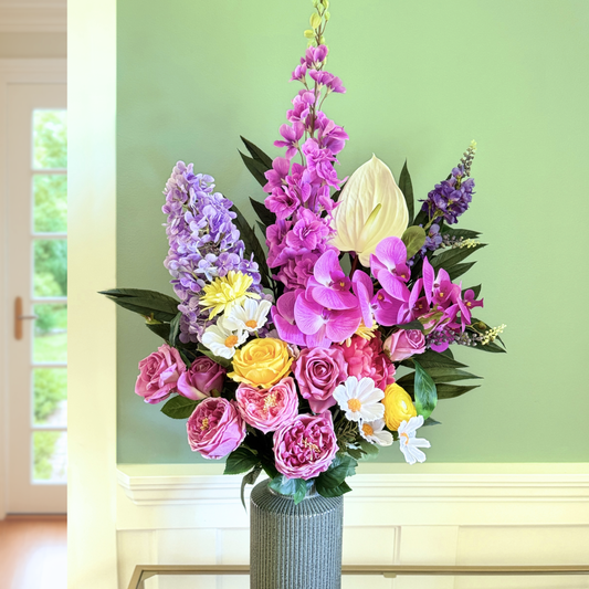 Bouquet of brightly coloured artificial flowers and Real Touch flowers in font of a green wall, by My Faux Florist artificial flowers Canada.
