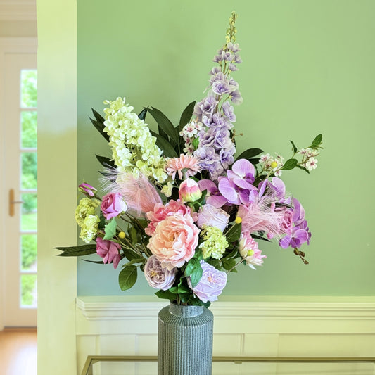 Bouquet of brightly coloured artificial flowers and Real Touch flowers against a green wall, by My Faux Florist artificial flowers Canada.