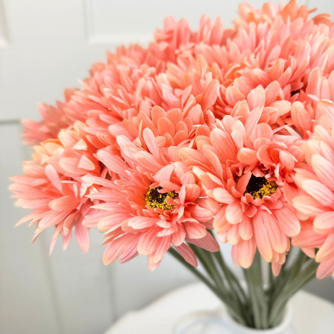 Bouquet of coral fake gerbera daisies in a vase against a white background from My Faux Florist Canada
