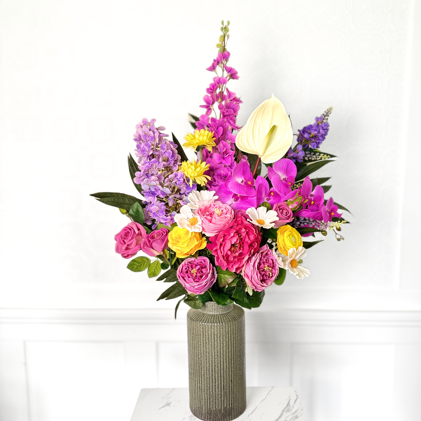 Bouquet of brightly coloured artificial flowers and Real Touch flowers in front of a white wall, by My Faux Florist artificial flowers Canada.