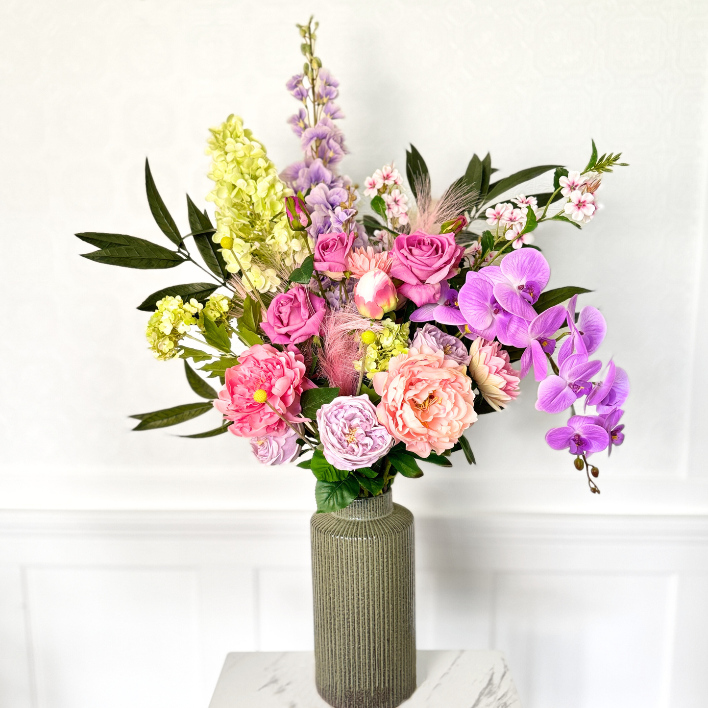 Bouquet of brightly coloured artificial flowers and Real Touch flowers against a white wall, by My Faux Florist artificial flowers Canada.