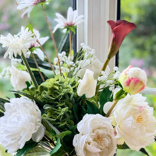 Close up of a Bouquet of neutral coloured artificial flowers and Real Touch flowers in front of a window, by My Faux Florist artificial flowers Canada.
