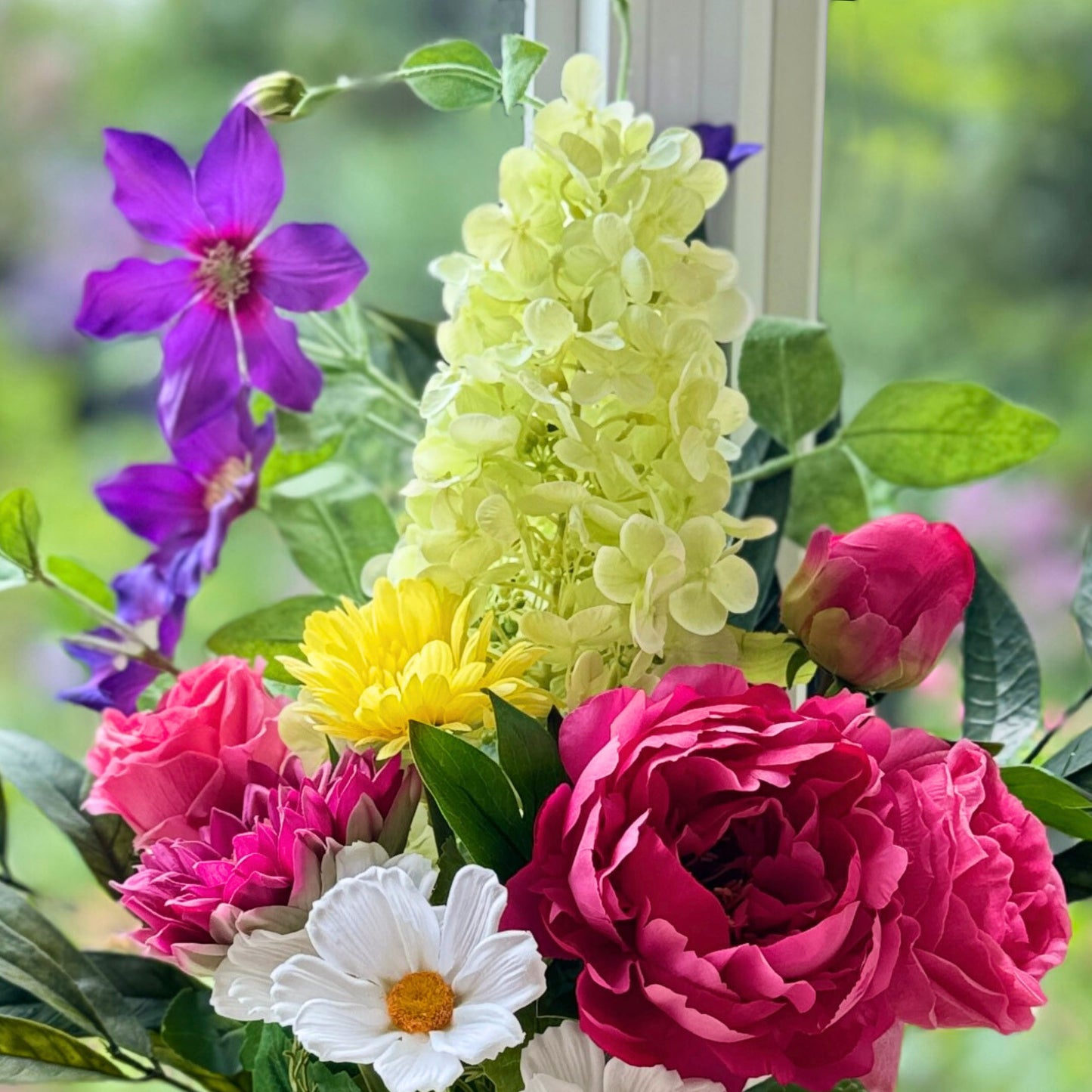 Close up of a Bouquet of brightly coloured realistic artificial flowers and Real Touch flowers in a window, by My Faux Florist artificial flowers Canada.