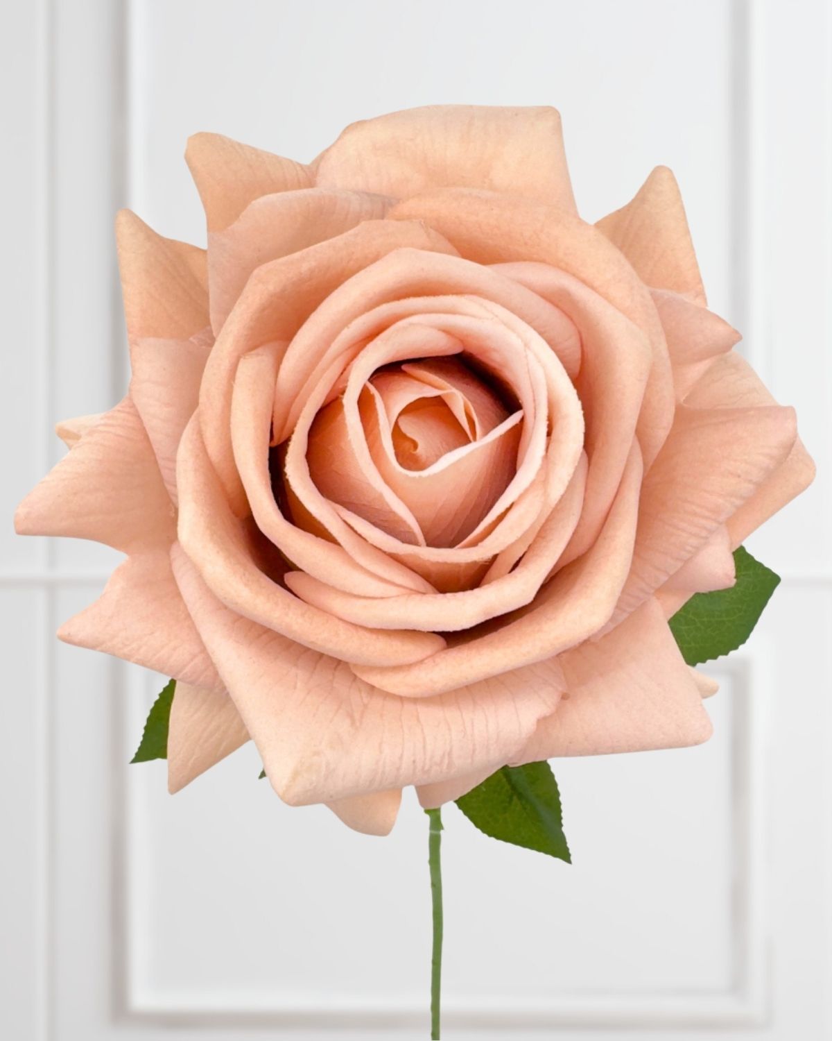 Artificial flower bouquet held by a florist, featuring faux roses, artificial mums, and fake greenery in soft neutral tones.