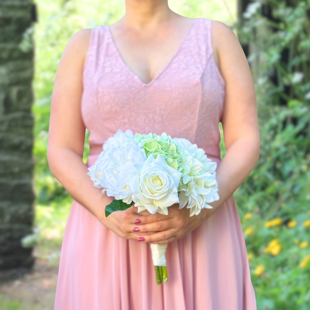 Bridesmaid holding a realistic artificial flower bouquet featuring white artificial roses, white artificial peonies, and pale green artificial hydrangeas — from My Faux Florist Canada.