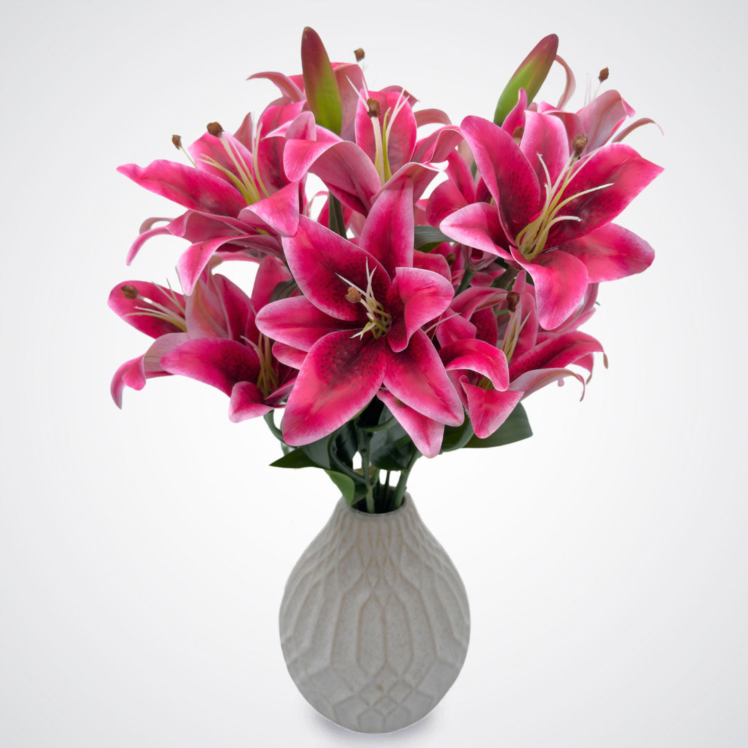 Vase full of premium realistic artificial oriental lilies in fuchsia color with green leaves by My Faux Florist.
