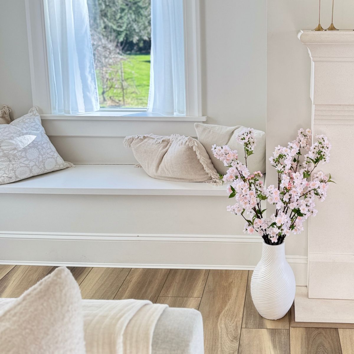 White vase with pink cherry blossom artificial flowers in a living room, for My Faux Florist Canada.