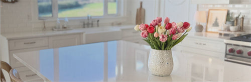 Kitchen counter with a vase of realistic artificial flowers and a window view.  Realistic artificial tulips from My Faux Florist Canada.