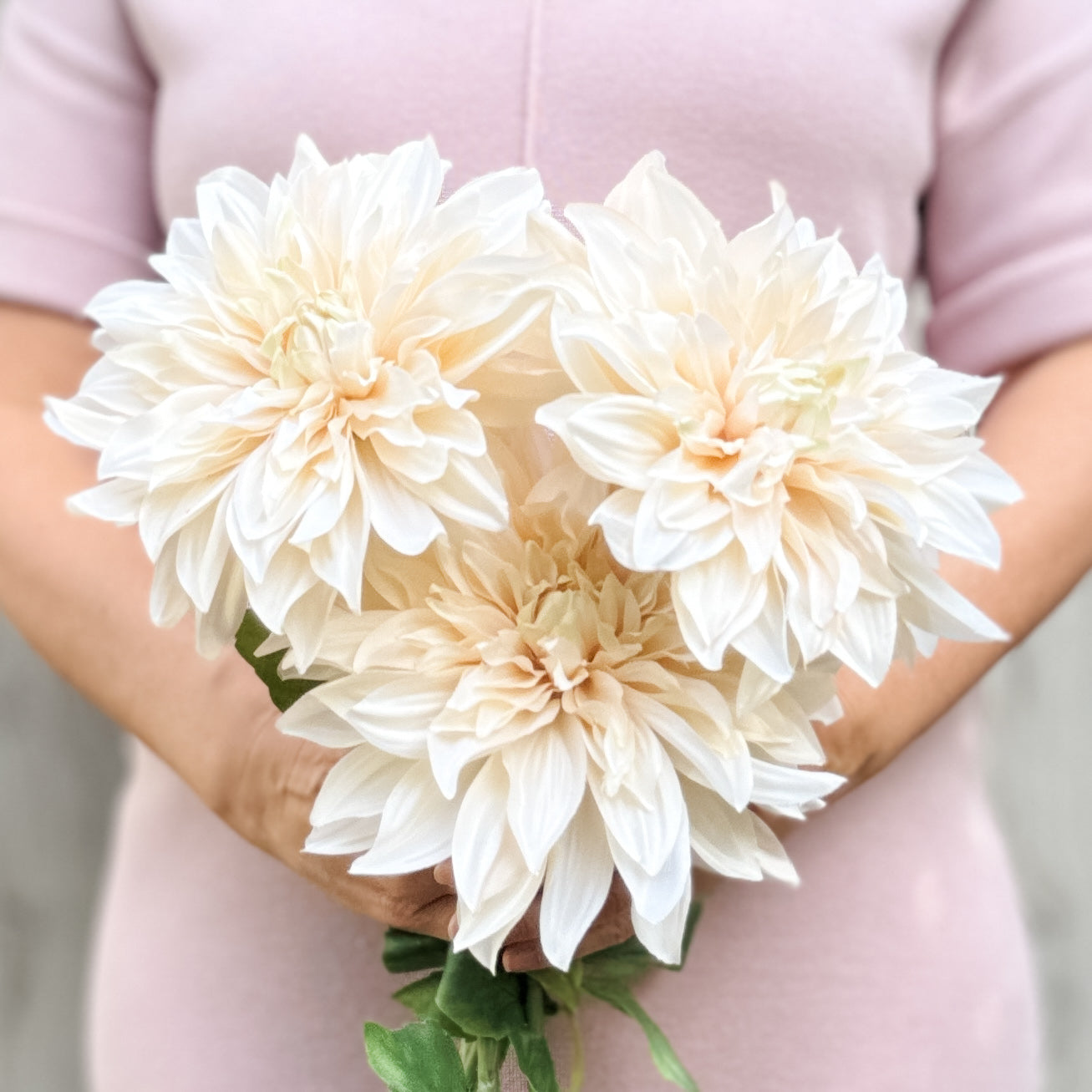 Person holding 3 artificial dahlias in a creamy white colour, from My Faux Florist artificial flowers Canada.