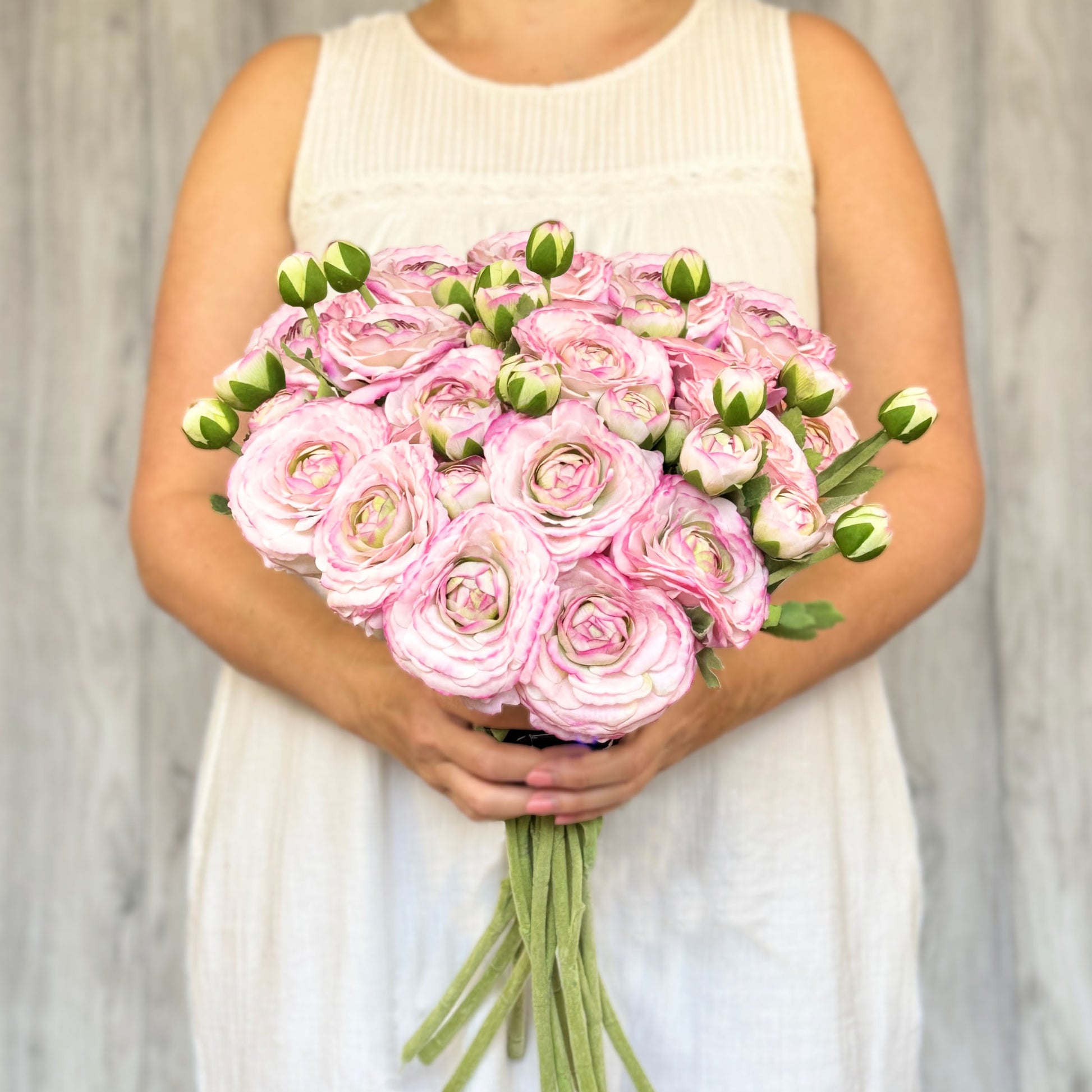 Woman holding bouquet of pink artificial ranunculus flowers, by Faux Florist Canada