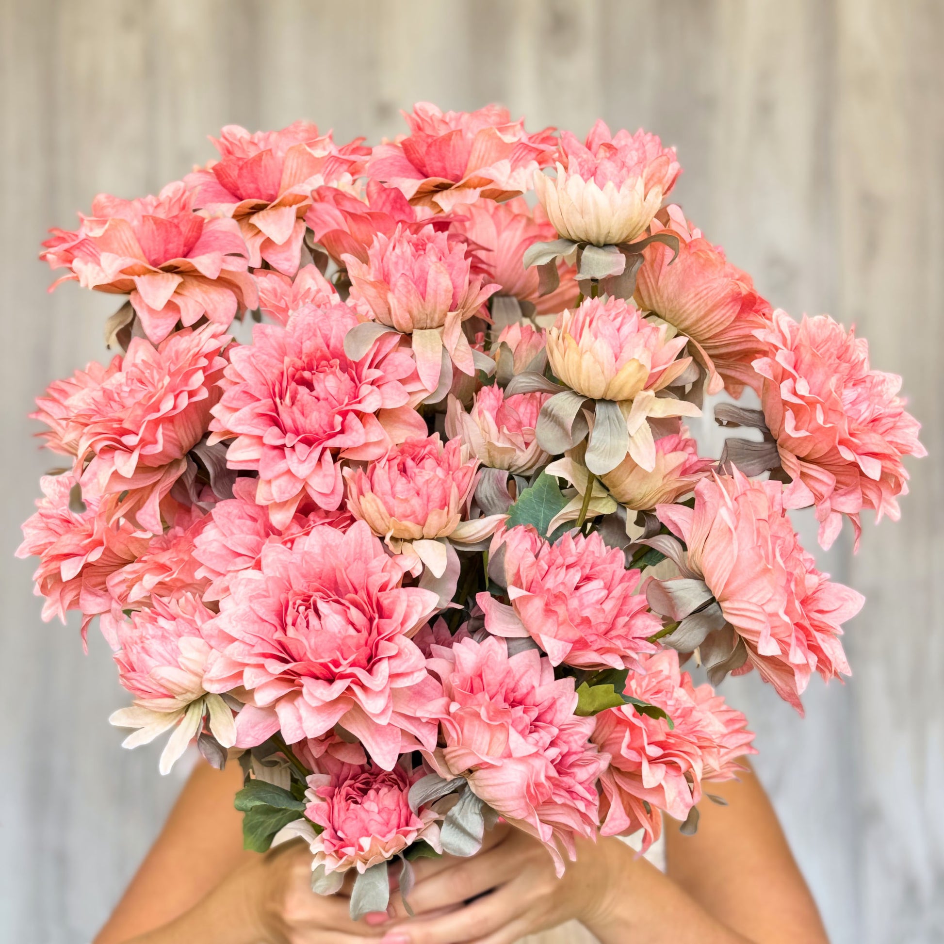 Woman holding bouquet of pink artificial dahlias, by Faux Florist Canada