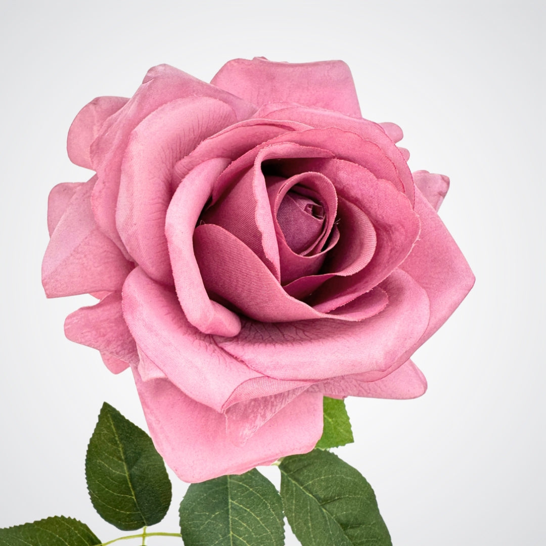 Close-up of a pink artificial rose with green leaves on a light background, from My Faux Florist Canada