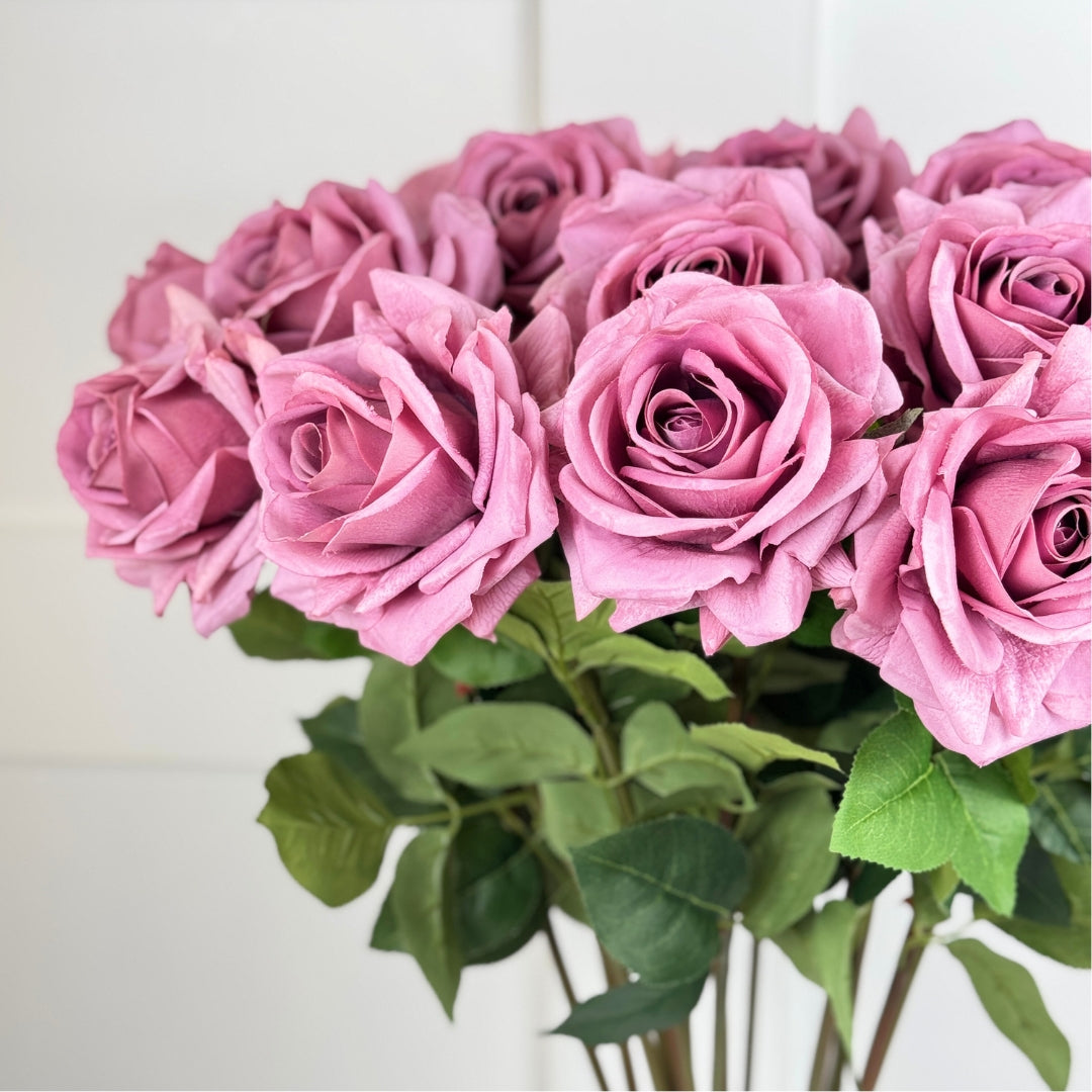 Vase of pink fake roses with green leaves on a neutral background, from My Faux Florist Canada.