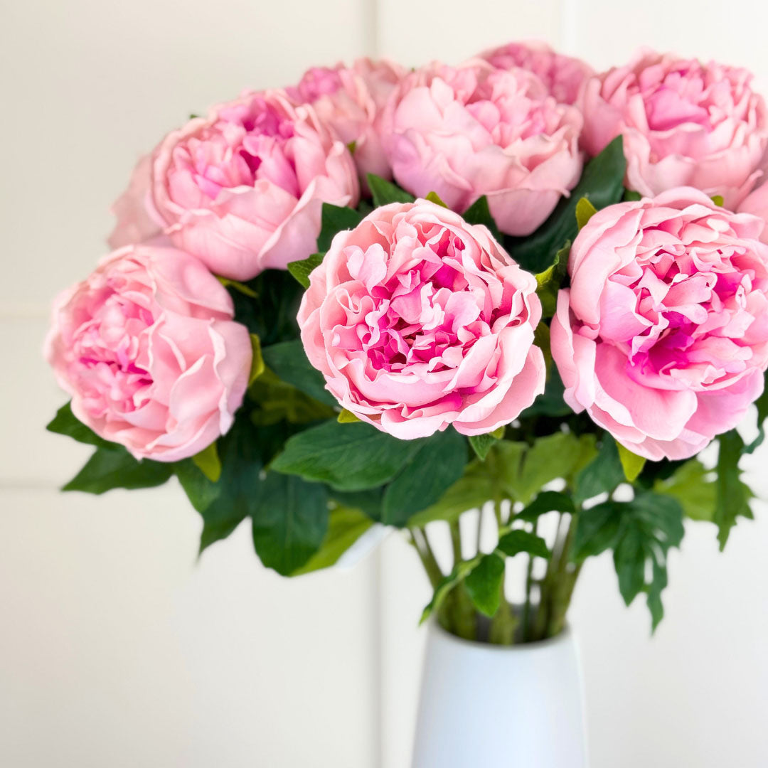White vase full of of artificial peonies in a warm pink colour with realistic Real Touch petals, from My Faux Florist artificial flowers Canada.