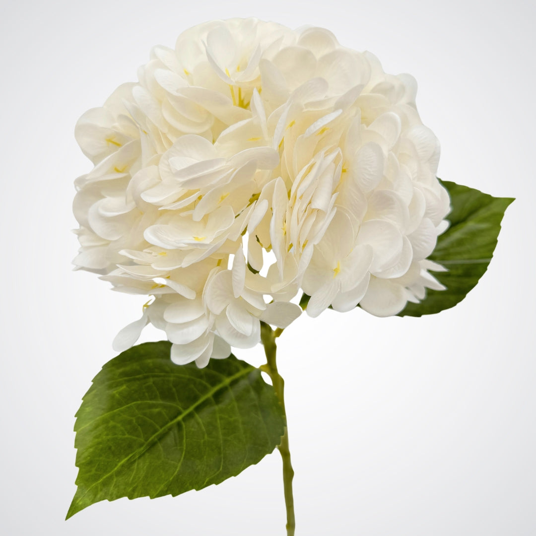 White artificial hydrangea stem with leaves shown from the side
