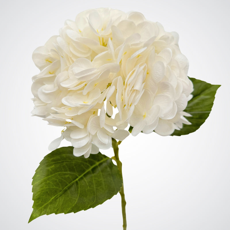 White artificial hydrangea stem with leaves shown from the side