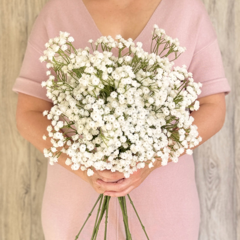 A person holding a bouquet of white artificial Baby's Breath flowers made by Real Touch, from My Faux Florist Canada