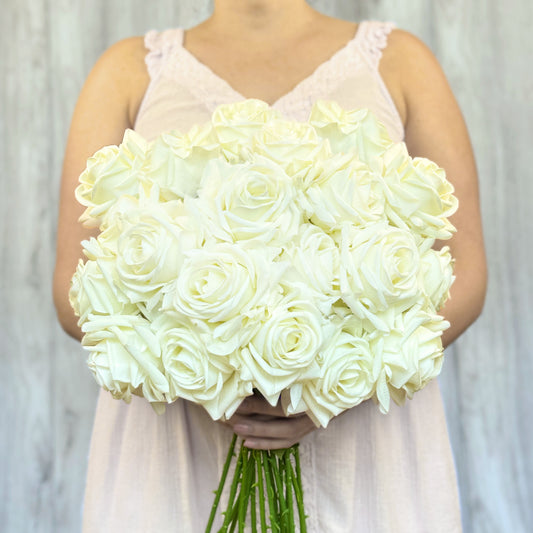 person holding a bouquet of whit realistic fake roses, against a grey background, for My Faux Florist Canada.