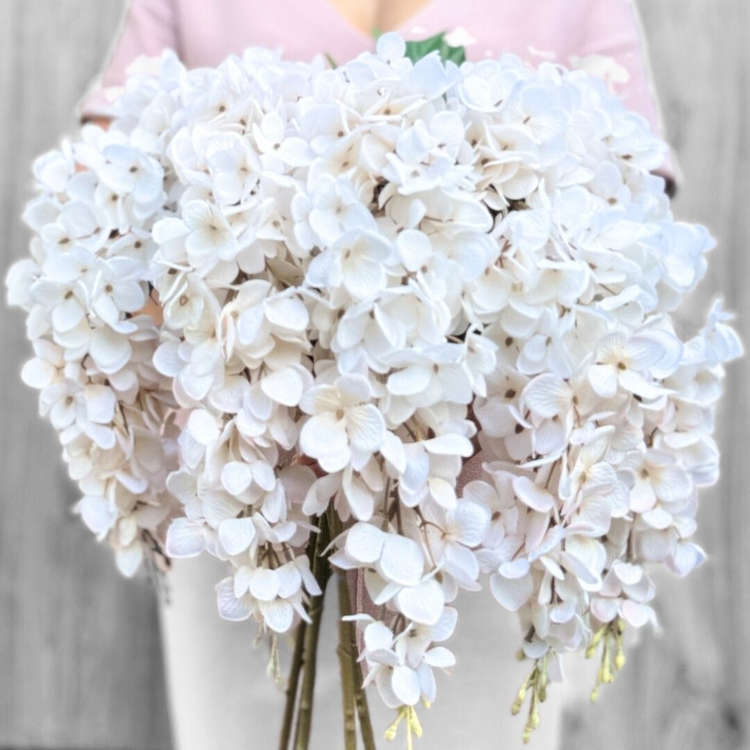 Person holding a large bunch of artificial wisteria branches in white, by My Faux Florist artificial flowers Canada.