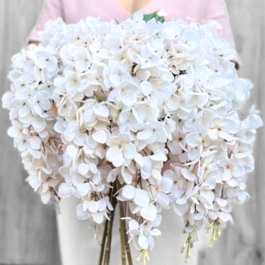 Person holding a large bunch of artificial wisteria branches in white, by My Faux Florist artificial flowers Canada.