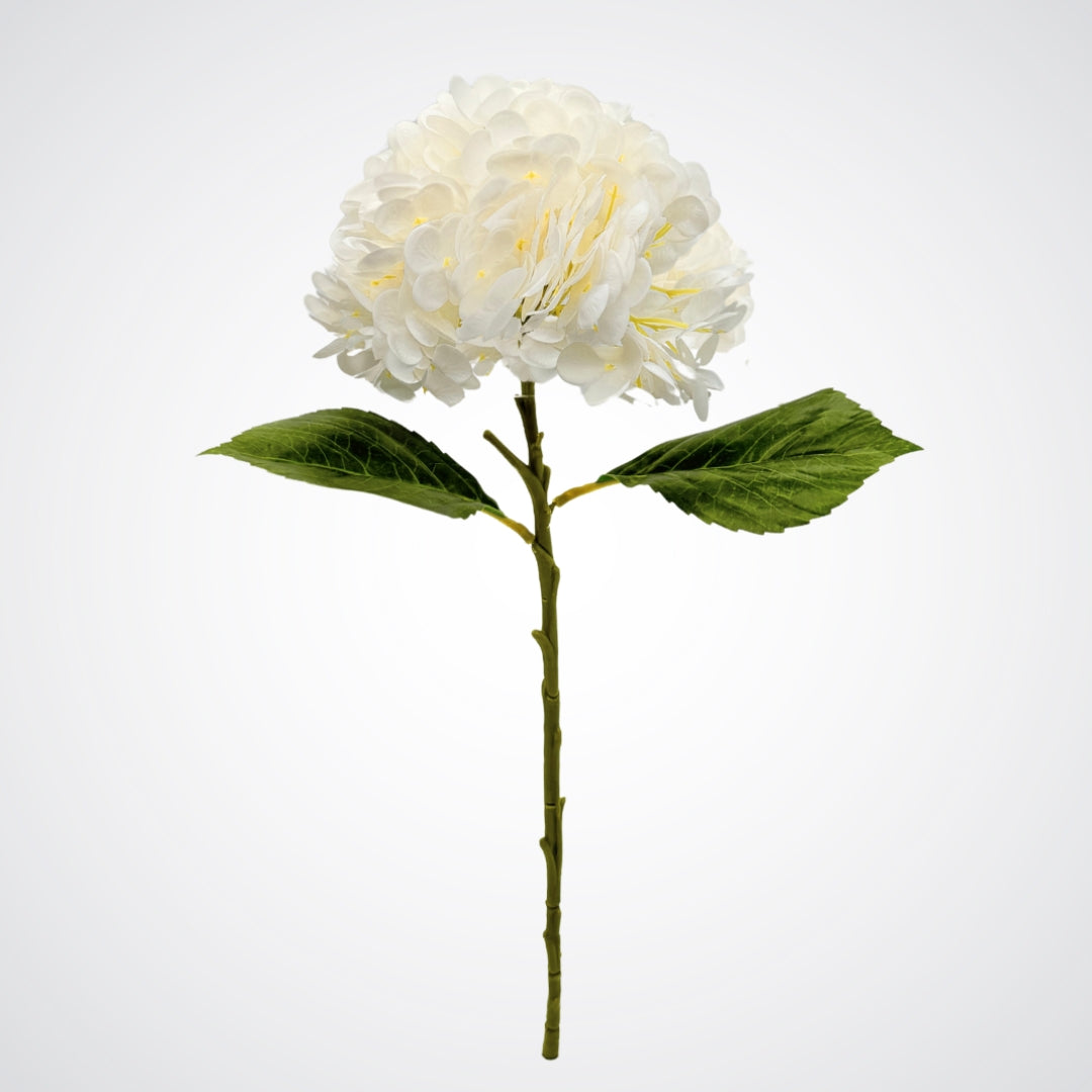 White artificial flower with green leaves on a white background