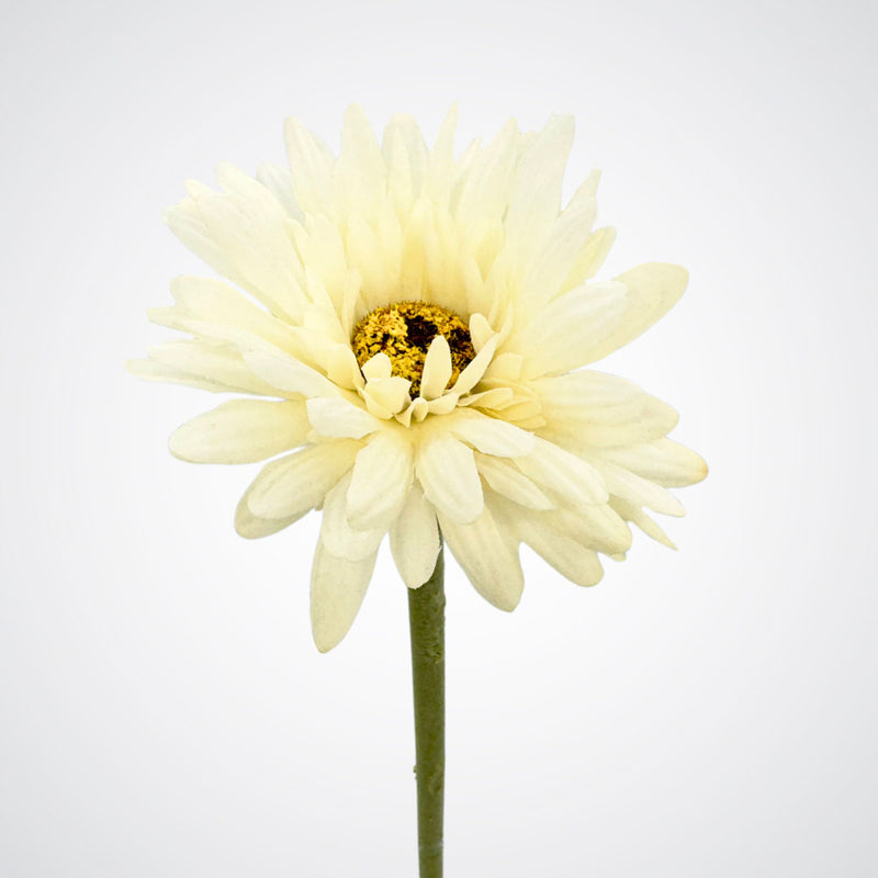 An artificial white daisy flower with a green stem, isolated on a white background.