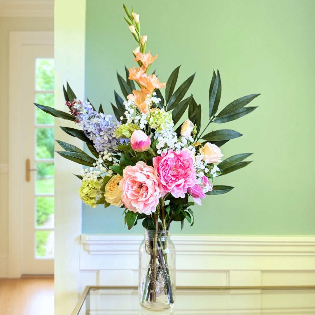 Bouquet of brightly coloured artificial flowers and Real Touch flowers in front of a green wall, by My Faux Florist artificial flowers Canada.