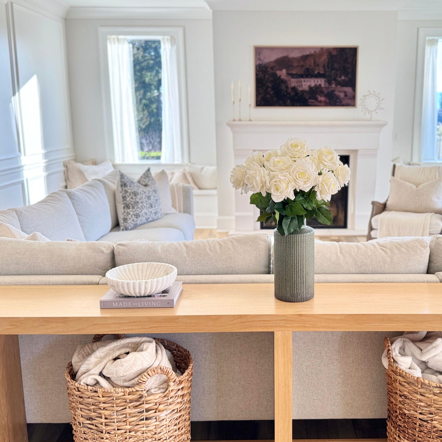 Living room with a sofa, coffee table, and decorative elements including a vase of realistic artificial roses for My Faux Florist Canada.