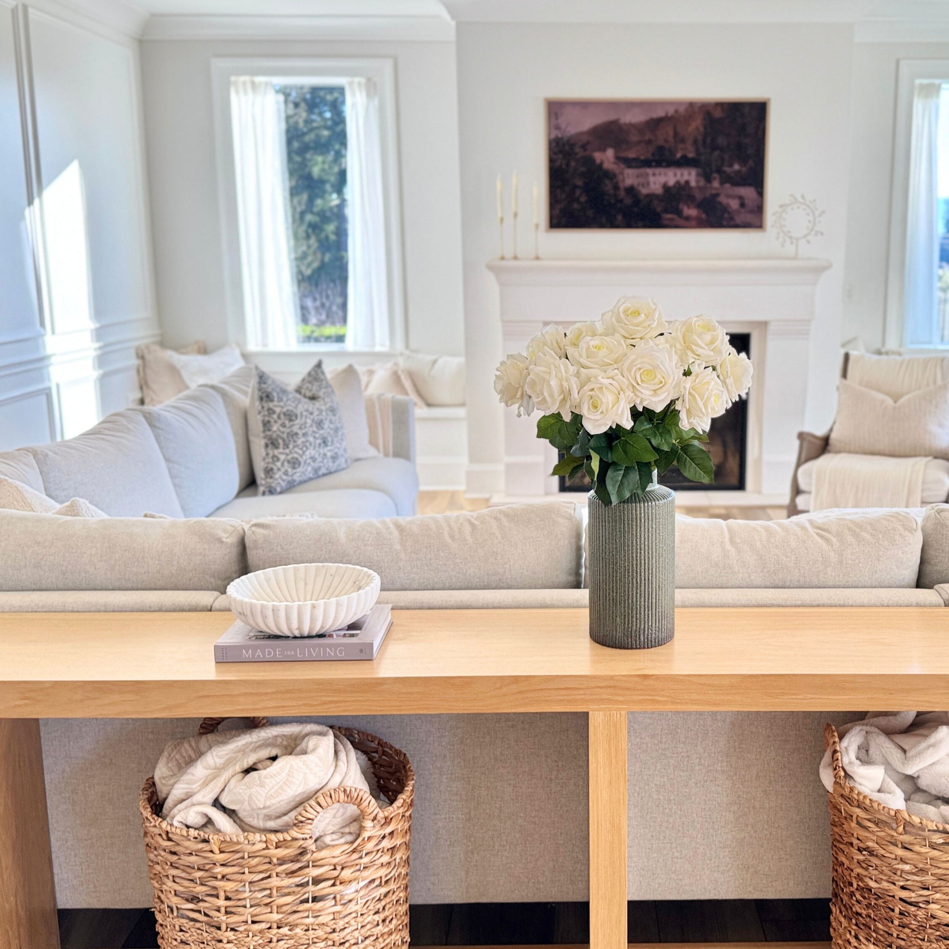 Living room with a sofa, coffee table, and decorative elements including a vase of realistic artificial roses for My Faux Florist Canada.