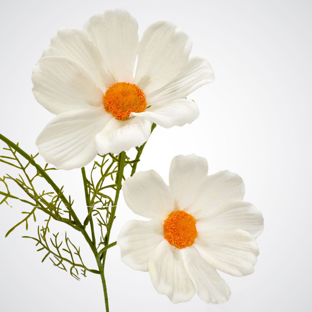 Close-up of a single white artificial cosmos flower with soft petals and bright center