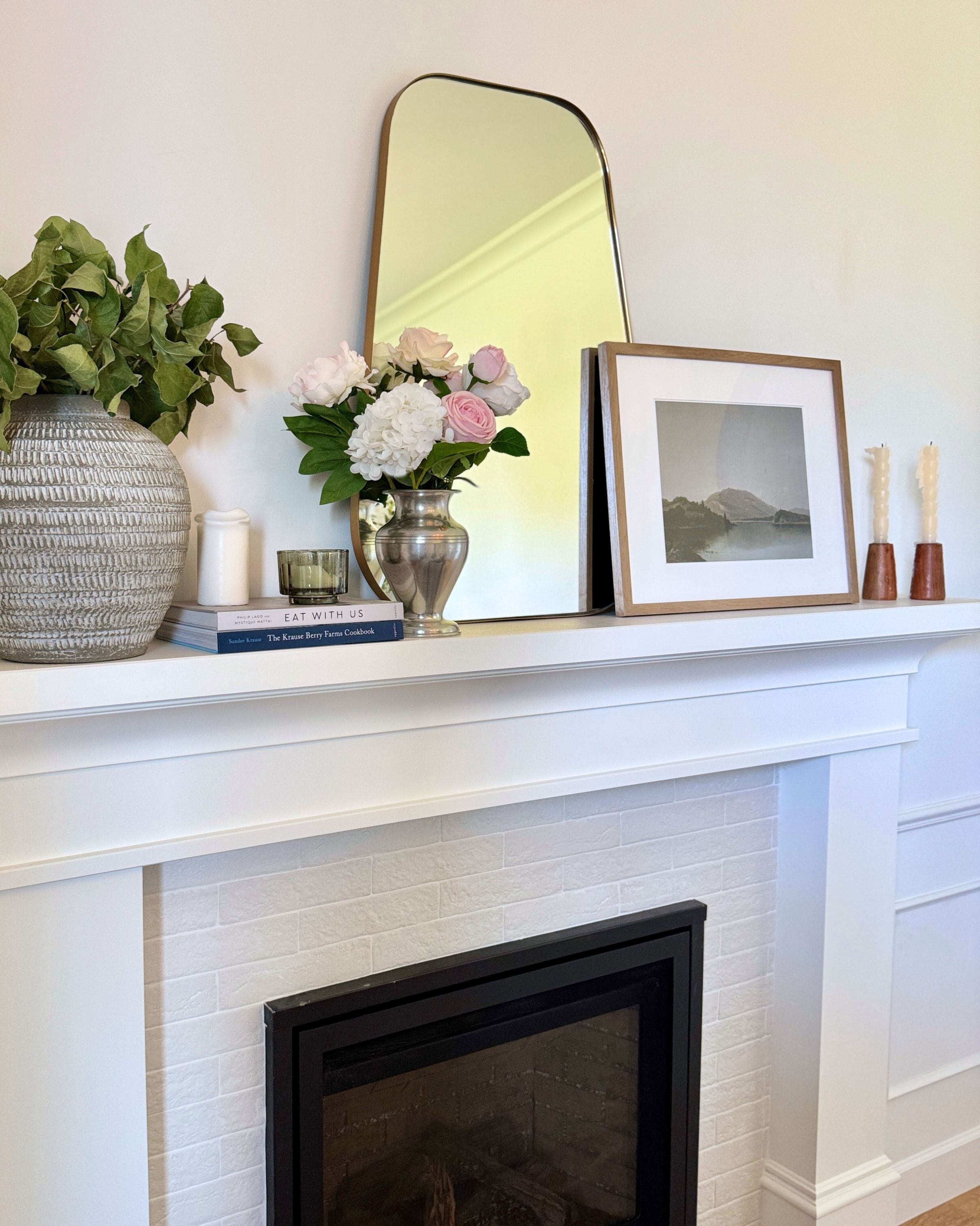 Decorative mantelpiece with a mirror, a bouquet or realistic artificial flowers, and framed picture above a fireplace. Faux peonies, faux roses, faux hydrangea, in an artificial flower bouquet for My Faux Florist Canada.