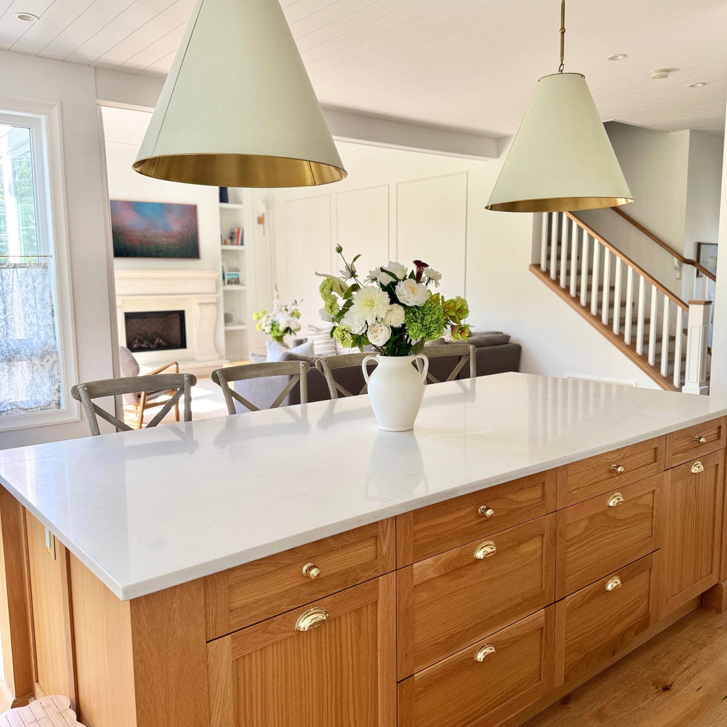Modern kitchen with wooden island, white countertops, and decorative realistic artificial flowers. Faux peonies, faux roses, faux hydrangea, and faux orchids in an artificial flower bouquet for My Faux Florist Canada.