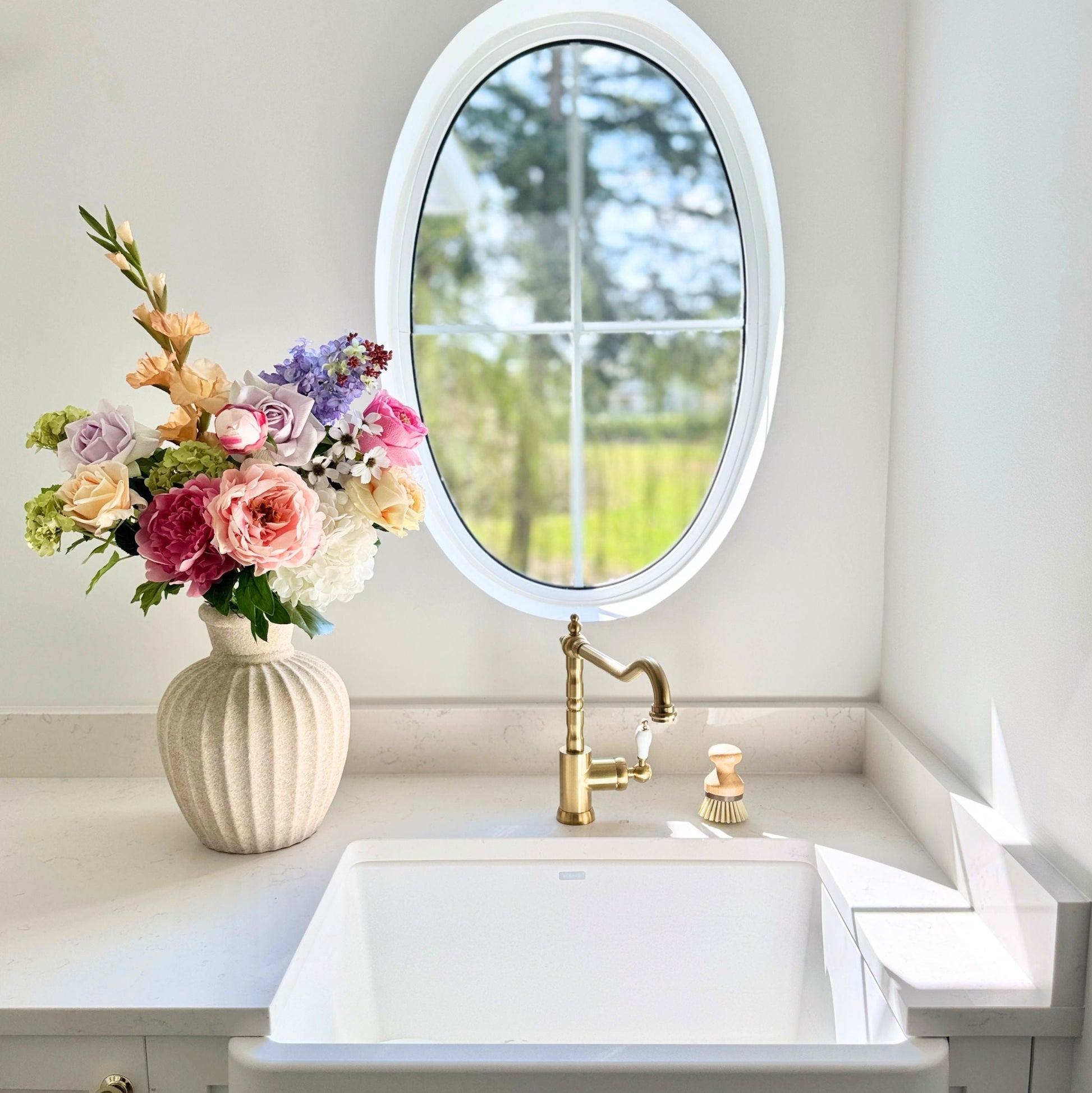 Bathroom vanity with sink, mirror, and a realistic artificial floral arrangement. Faux peonies, faux roses, faux hydrangea, and faux orchids in an artificial flower bouquet for My Faux Florist Canada.