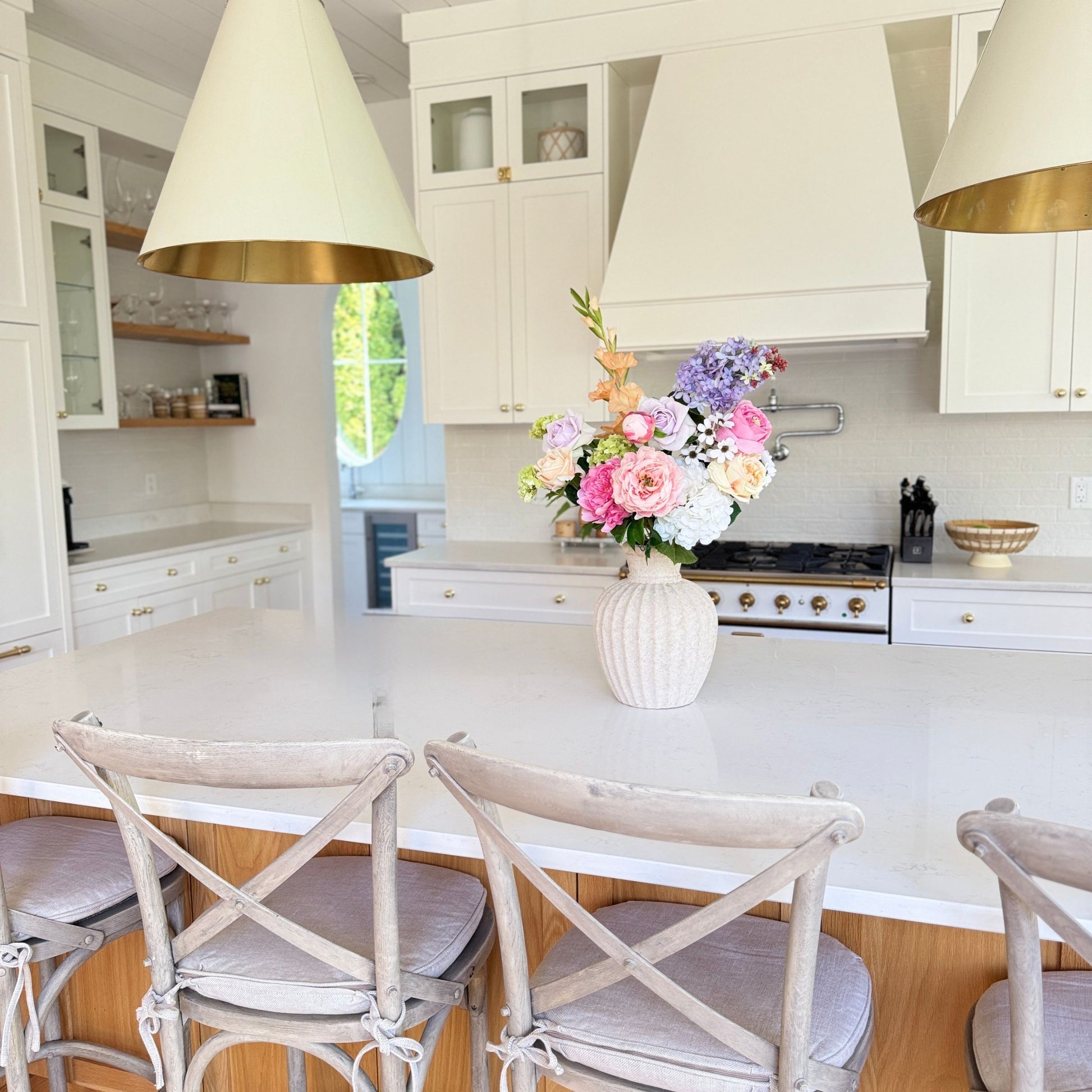 Modern kitchen with white island, chairs, and a vase of realistic artificial flowers. Faux peonies, faux roses, faux hydrangea  for My Faux Florist Canada.