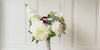 Turntable showcasing a realistic artificial flower bridal bouquet featuring pale green artificial hydrangeas, white artificial dahlias, white artificial peonies, white artificial tea roses, white artificial Austin roses, and deep wine artificial calla lilies accented with soft lamb’s ear greenery — from My Faux Florist Canada.