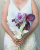 Bride holding a realistic artificial flower bridal bouquet featuring white artificial orchids, deep wine artificial calla lilies, white artificial calla lilies, and lavender artificial tulips — from My Faux Florist Canada.