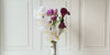 Turntable showcasing  a realistic artificial flower bridal bouquet featuring white artificial orchids, deep wine artificial calla lilies, white artificial calla lilies, and lavender artificial tulips — from My Faux Florist Canada.
