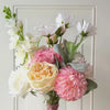 turntable showcasing  a realistic artificial flower bouquet for bridesmaids featuring white artificial cosmos, blush artificial peonies, apricot artificial tulips, cream artificial tea roses, pink artificial hydrangeas, and pale green artificial stock with lamb’s ear greenery — from My Faux Florist Canada.