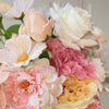 Turntable showcasing  a realistic artificial flower bridal bouquet featuring white artificial roses, blush artificial peonies, apricot artificial tulips, cream artificial tea roses, pink artificial hydrangeas, and white artificial cosmos — from My Faux Florist Canada.