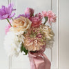turntable showcasing a realistic artificial flower bouquet for bridesmaids featuring pink artificial tulips, champagne artificial tea roses, blush artificial peonies, white artificial hydrangeas, pink artificial dahlias, and lavender artificial cosmos tied with a satin ribbon — from My Faux Florist Canada.