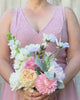 Bridesmaid holding a realistic artificial flower bouquet featuring white artificial cosmos, blush artificial peonies, apricot artificial tulips, cream artificial tea roses, pink artificial hydrangeas, and pale green artificial stock with lamb’s ear greenery — from My Faux Florist Canada.