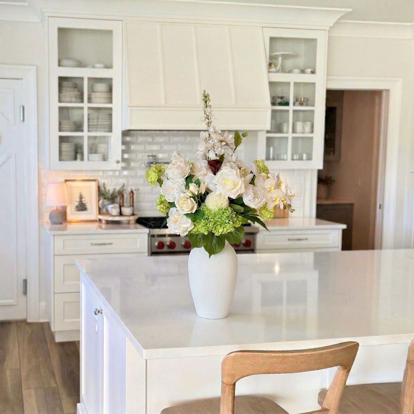 White kitchen with a vase of realistic artificial flowers on the counter. Faux peonies, faux roses, faux hydrangea, and faux orchids in an artificial flower bouquet for My Faux Florist Canada.